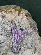 Moana Tide patterned bikini bottom on a rock by water
